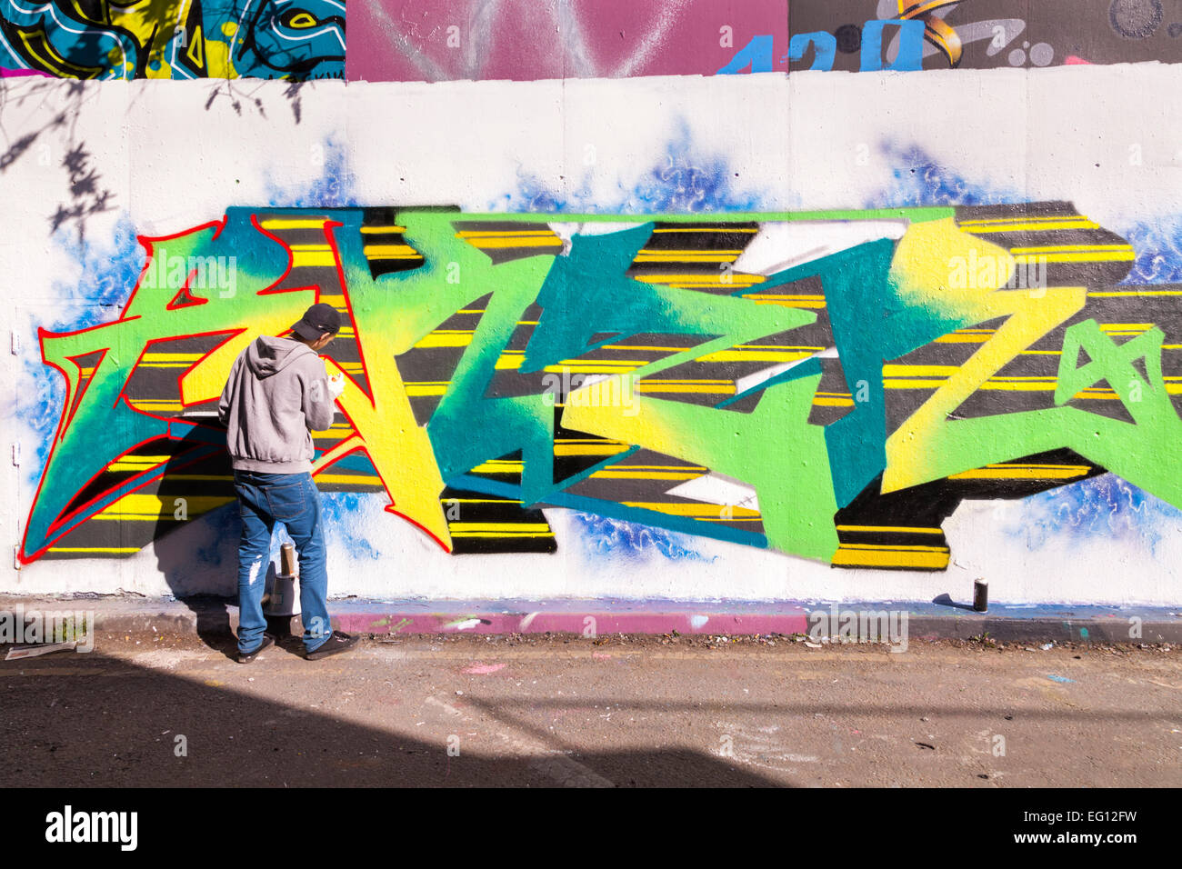 Streetart-Künstler bei der Arbeit an "The Tunnel", eine autorisierte Graffiti-Gebiet bei Leake Street in der Nähe von Waterloo Station in London Stockfoto