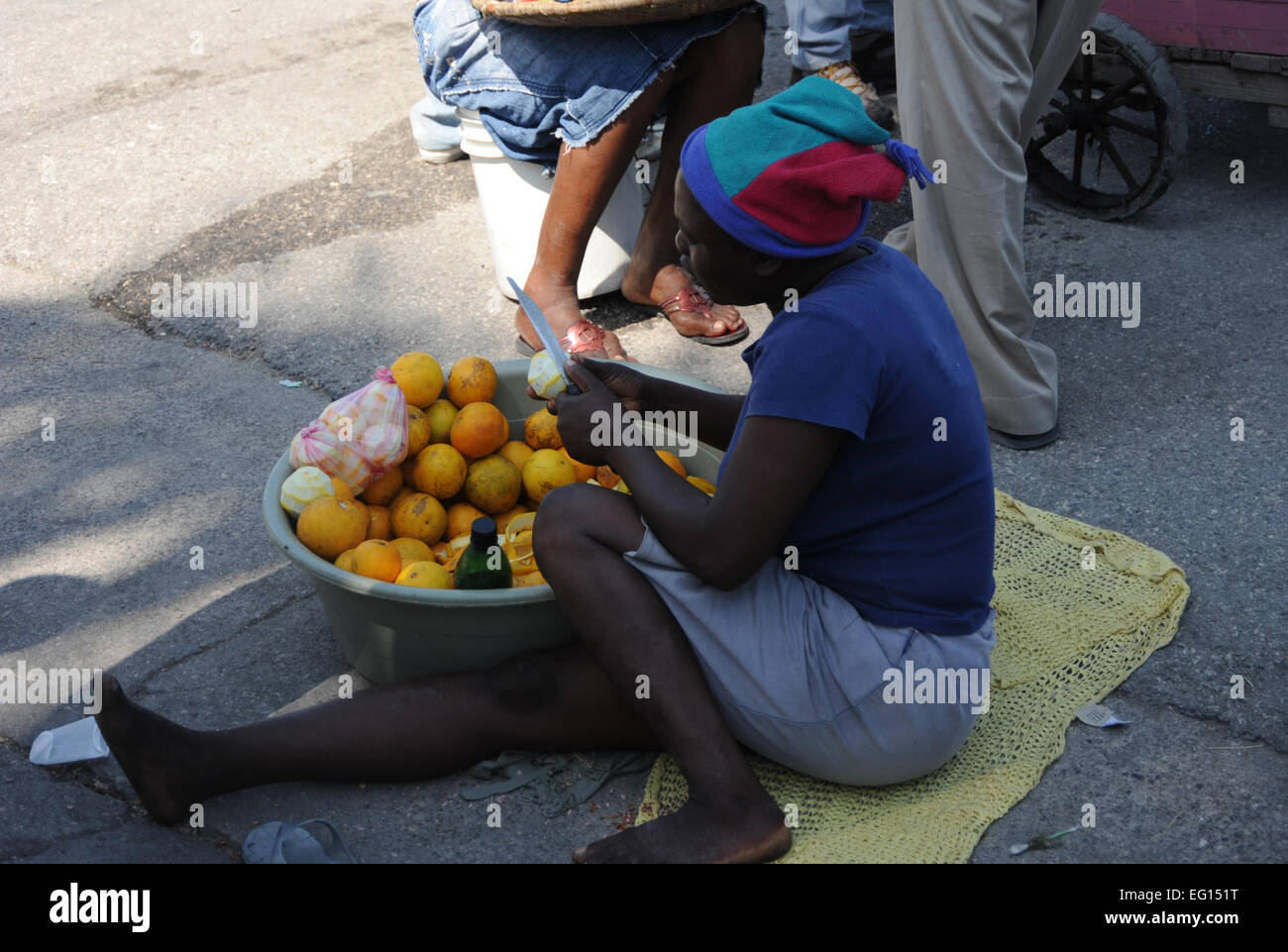 Eine haitianische Frau schält Orangen auf der Straße in Port au Prince, Haiti am 22. Januar 2010 zu verkaufen. Eine Erdbeben der Stärke 7,0 verwüstet Haiti am 12. Januar 2010 techn. Sgt. Prentice Colter veröffentlicht Stockfoto