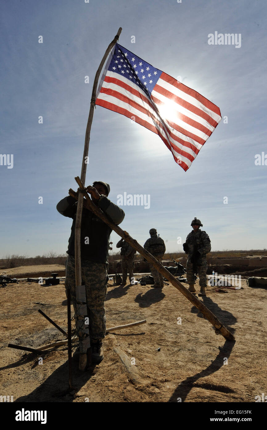 US-Soldaten mit Alpha Company, 1. Bataillon, 17. Infanterie-Regiment heben eine amerikanische Flagge auf einem Dach, der für einen Look out-Point während der Operation Helmand Spider, Badula Qulp, Provinz Helmand, Afghanistan, 10. Februar 2010 verwendet wird.  Techn. Sgt Efren Lopez Stockfoto