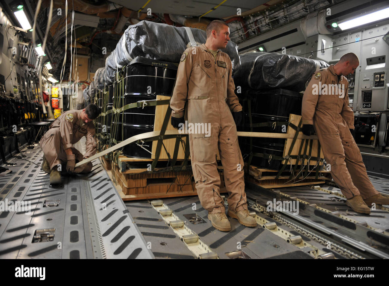 us-air-force-loadmaster-senior-airman-josh-faust-links-gurte-container-liefersystem-b-ndel-auf-den-boden-einer-c-17-globemaster-iii-w-hrend-loadmaster-staff-sgt-gabriel-reams-zentrieren-und-pilot-captain-dave-goodale