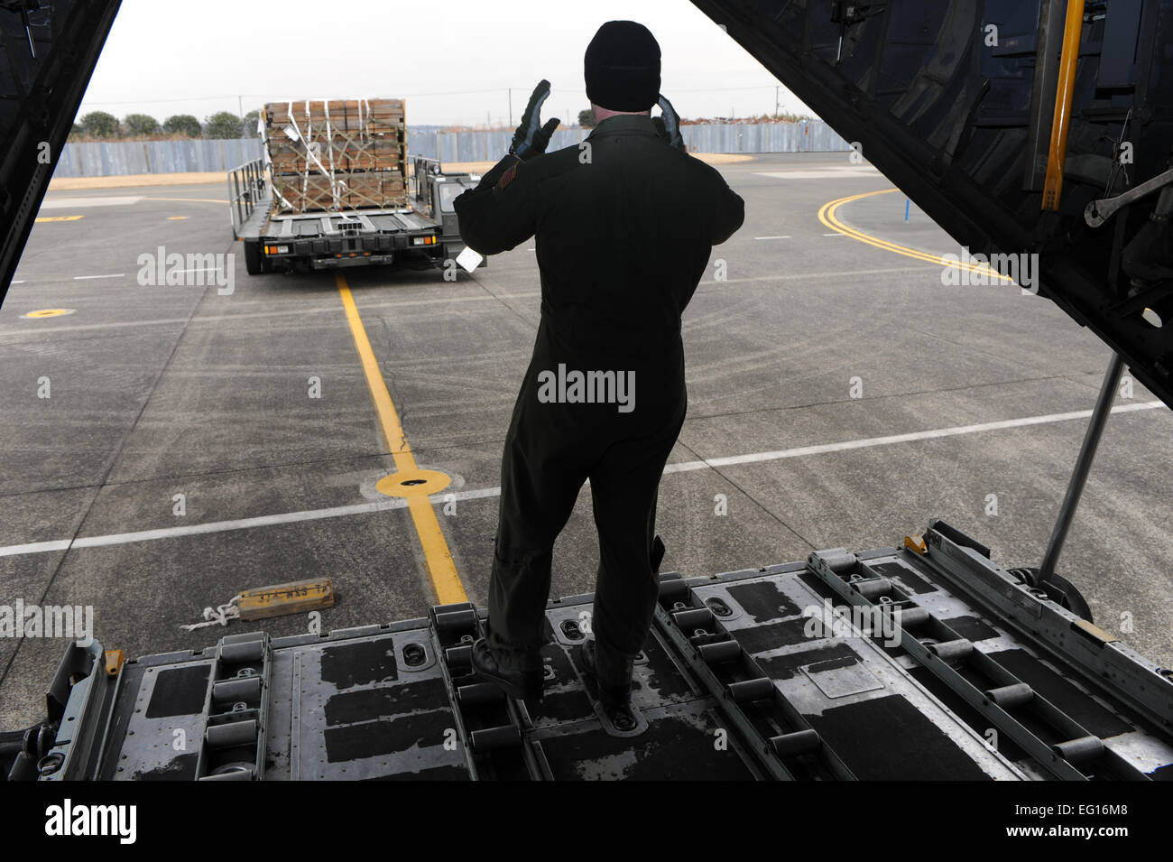 U.S. Air Force c-130 Hercules Load Master, Personal. Sgt. Blake Landry aus der 36. Airlift Squadron, Yokota Air Base, Japan, führt Ladung in seinem Flugzeug für den Transport zur Misawa Air Base, Japan zur Unterstützung der Operation Tomodachi. Im Rahmen der Operation Tomodachi hat das Militär der Vereinigten Staaten humanitäre Hilfe-Funktionen in der betroffenen Region positioniert, die Katastrophenhilfe auf Ersuchen der Regierung von Japan unterstützen. Foto von: US Air Force Tech Sg.t DeNoris A. Mickle Stockfoto