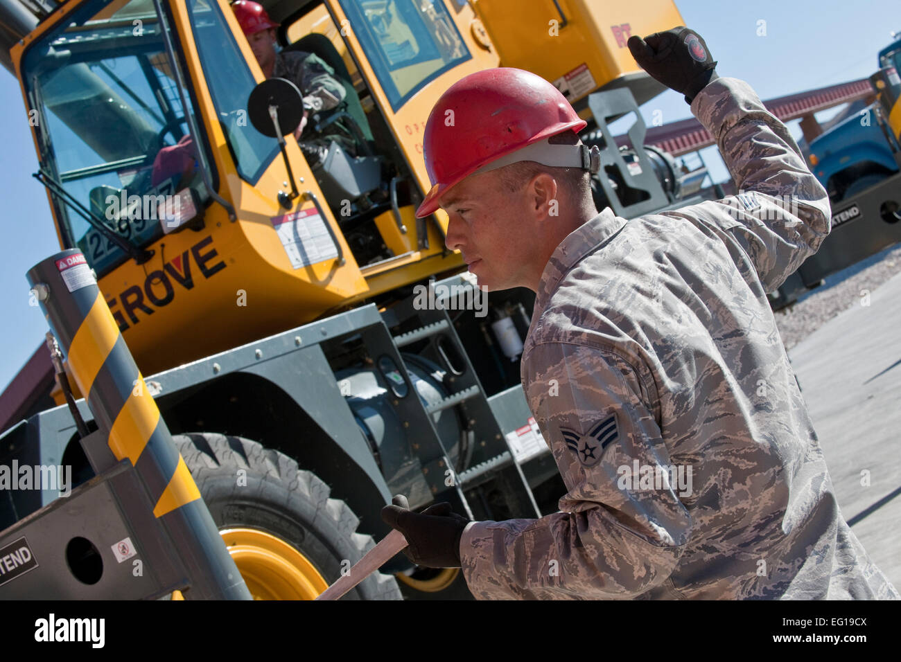 US Air Force Senior Airman Robert Goll, ein 820th Rapid Ingenieur einsetzbare schwere operative Reparatur Squadron Ingenieure Red Horse schwere Ausrüstung Betreiber, leitet einen Kran auf der Nellis Air Force Base in Nevada, 21. Januar 2011 zu stoppen. Soldaten aus dem 647th-Quartiermeister-Unternehmen von Fort Bragg, N.C., verbunden mit Flieger von der 820th roten Pferd Squadron, Nellis Air Force Base, Nevada, die erste operative niedriger Geschwindigkeit Airdrop eine 277 multi-Terrain-Loader auf der Nevada Test und Trainingsbereich Rig. Die Airdrop gehörten auch zwei geländegängigen Fahrzeugen und rund 40 Mitarbeiter aus Nellis und M Stockfoto