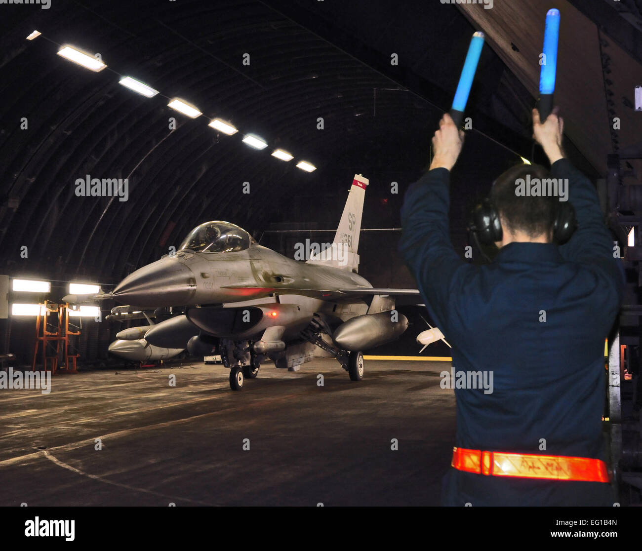 Eine Crew Chief aus der 52. Aircraft Maintenance Squadron Marschälle ein US Air Force f-16 Fighting Falcon aus einem gehärteten Flugzeug Tierheim 20. März 2011, auf der Spangdahlem Air Base, Deutschland, zur Unterstützung der Operation Odyssey Dawn. Gemeinsame Task Force JTF Odyssey Dawn ist die US Africa Command-Task-Force gegründet, um operative und taktische Kommando und Kontrolle des US-Militärs Kräfte unterstützen die internationale Reaktion auf die Unruhen in Libyen und Durchsetzung von UN Security Council Resolution Resolution 1973. Resolution 1973 ermächtigt, alle erforderliche Maßnahmen zum Schutz der Zivilbevölkerung in Libyen Stockfoto