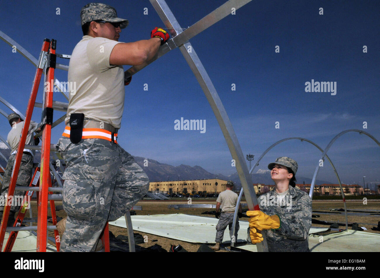 US Air Force Tech SGT Selvin Hudson, ein 48. Bauingenieur-Geschwader strukturelle Handwerker aus Royal Air Force Lakenheath, Vereinigtes Königreich und 1st Lt. Elizabeth Hoeltje, der 31. Mission Support Group Executive Officer, bauen Alaskan kleine Tierheim Zelte 22. März 2011, für unvorhergesehene Ausgaben Personal ankommen zu Aviano Air Base, Italien, zur Unterstützung der gemeinsamen Task Force JTF Odyssey Dawn. JTF Odyssey Dawn ist die US Africa Command-Task-Force eingerichtet, um die größere internationale Reaktion auf die Unruhen in Libyen zu unterstützen. Eine breite Koalition von Nationen sind eine Partnerschaft zur Durchsetzung der UN-Sicherheitsrat Res Stockfoto