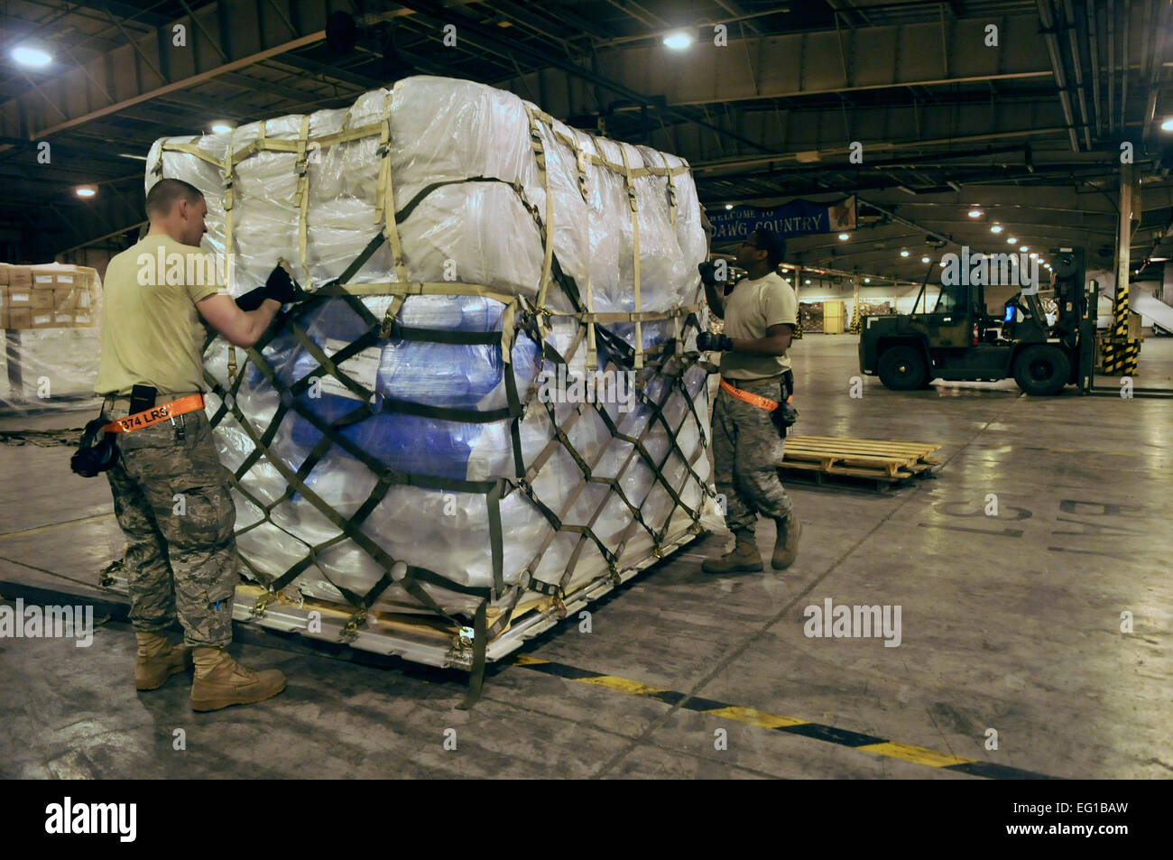 US Air Force Airman 1st Class James Carr und Staff Sgt Smith Warren Smith, beide 374th Logistik Bereitschaft Squadron Air Transport Spezialisten sichern eine Palette von Decken im Inneren ein Fracht-Lager auf der Yokota Air Base, Japan, 20. März 2011. Die Hilfsgüter sollen zur Unterstützung der Operation Tomodachi geliefert werden.  Flieger 1. Klasse Andrea Salazar Stockfoto