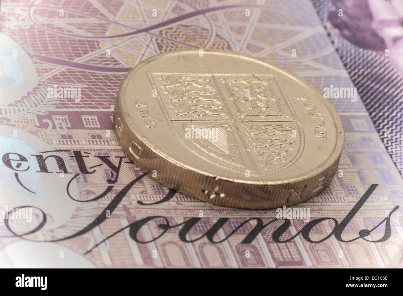 Nahaufnahme einer ein Pfund-Münze platziert auf einer zwanzig Pfund-Banknote - Studio gedreht Stockfoto