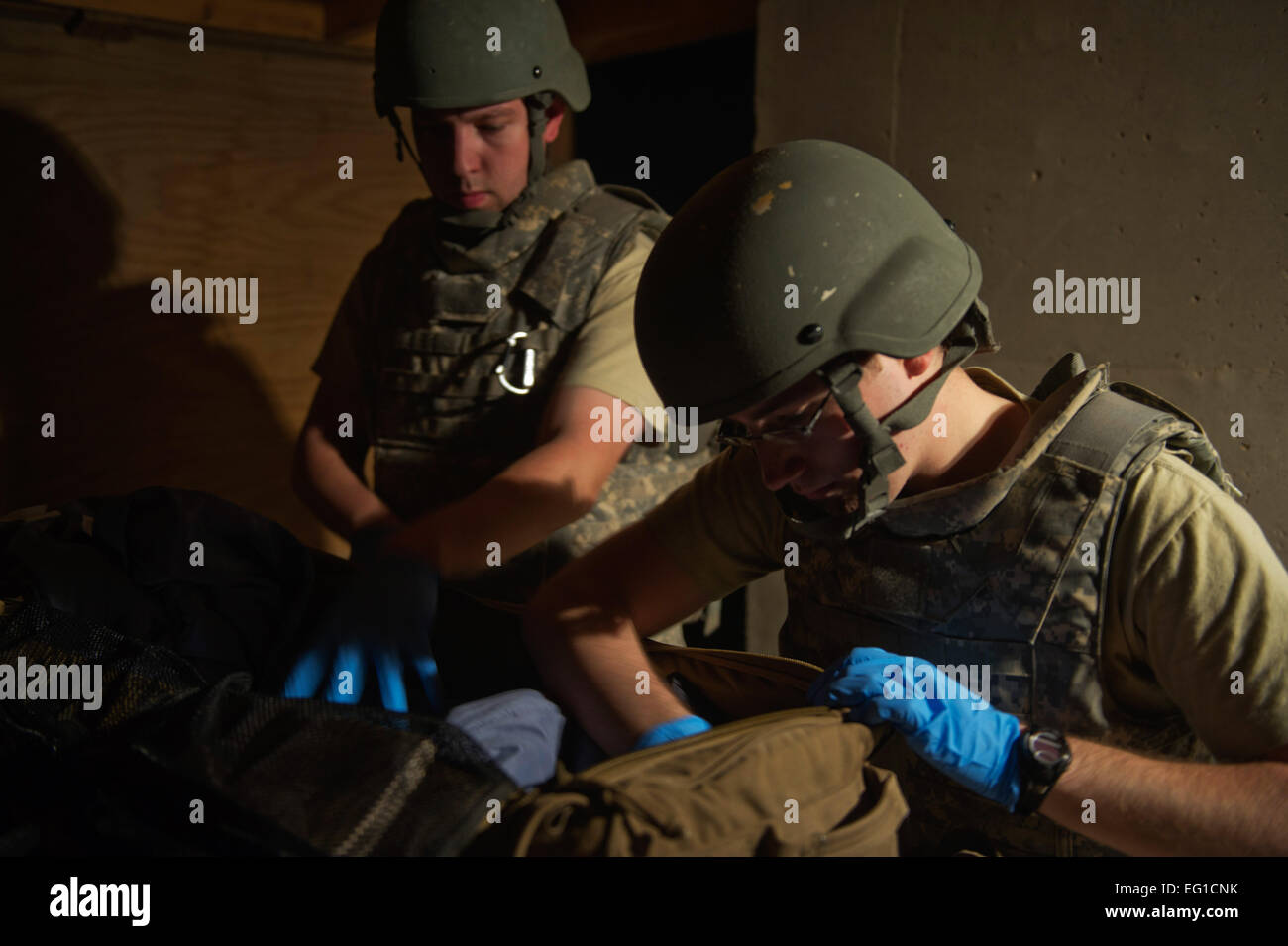 US Air Force Senior Airman Cyril McKenney, links, und Flieger 1. Klasse Dennis Nellessen, beide 451st Expeditionary Aeromedical Evakuierung Squadron Ablösung 1 Contingency Aeromedical Staging Facility CASF Luft-und Medizintechniker, suchen die Tasche eines verwundeten Marines für potenziell gefährliche oder Schmuggelware Gegenstände während einer antihijacking Prüfung vor dem Laden verwundete Marines auf ein Luftwaffe c-130 Hercules Cargo Flugzeug in Camp Bastion Afghanistan. McKenney und Nellessen werden bereitgestellt von der 633rd medizinischen Operations Squadron, gemeinsame Basis Langley-Eustis, Virginia   Master Sergeant Adrian Cadi Stockfoto