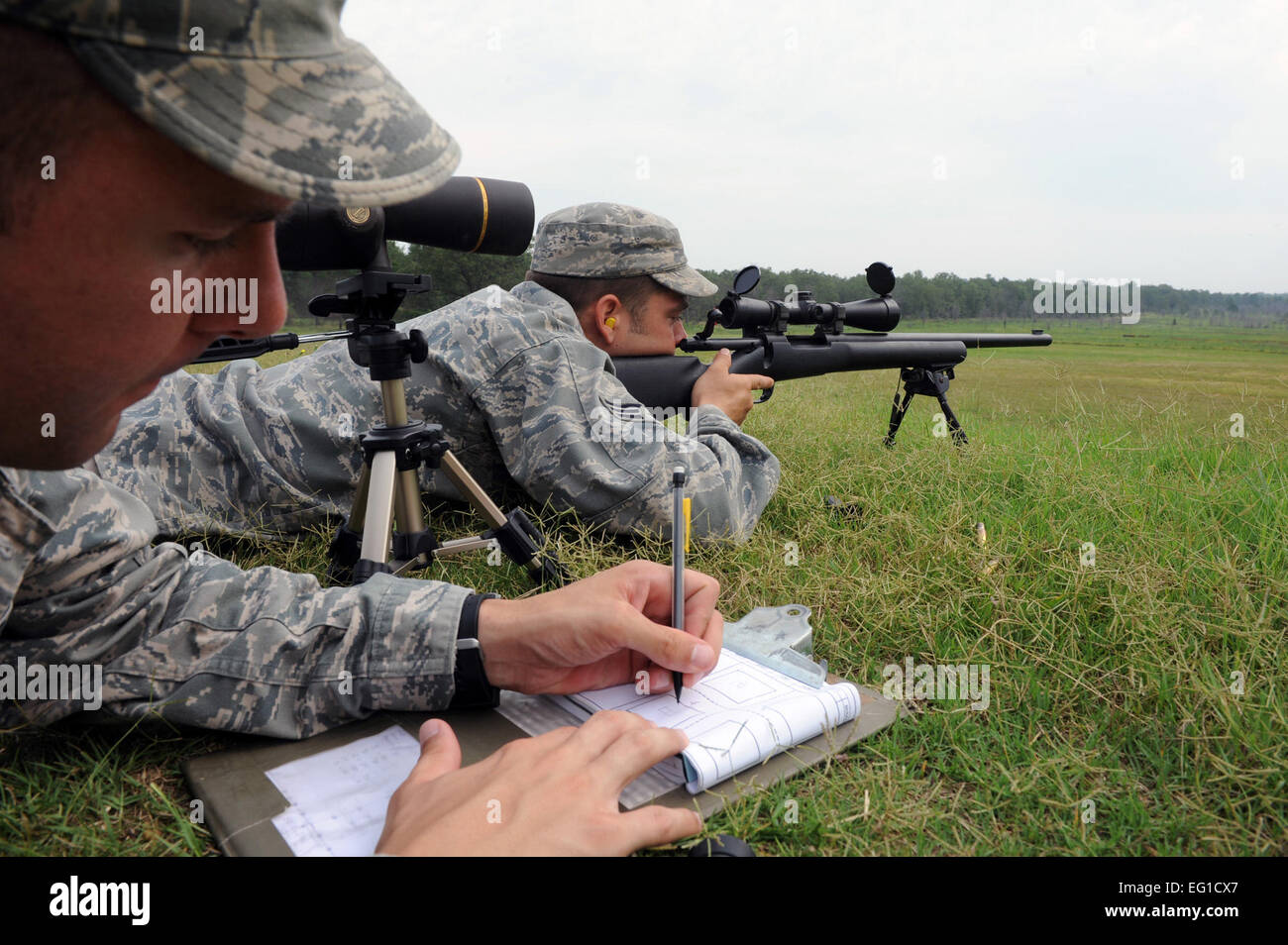 US Air Force Staff Sgt Carl Hook hilft ein Ziel für den Senior Airman Timothy Kragen zu finden, denn er bereitet sich auf eine m-24 Gewehr Feuer 7. Juli 2011, am Camp Robinson, Arche, während fortgeschrittene ausgewiesenen Schütze training in Vorbereitung auf die 2011 Air Mobility Rodeo. Haken und Kragen sind Trainer zur 19. Sicherheit Kräfte Squadron versetzt in Little Rock Air Force Base, Ark.  Airman 1st Class Rusty Frank Stockfoto