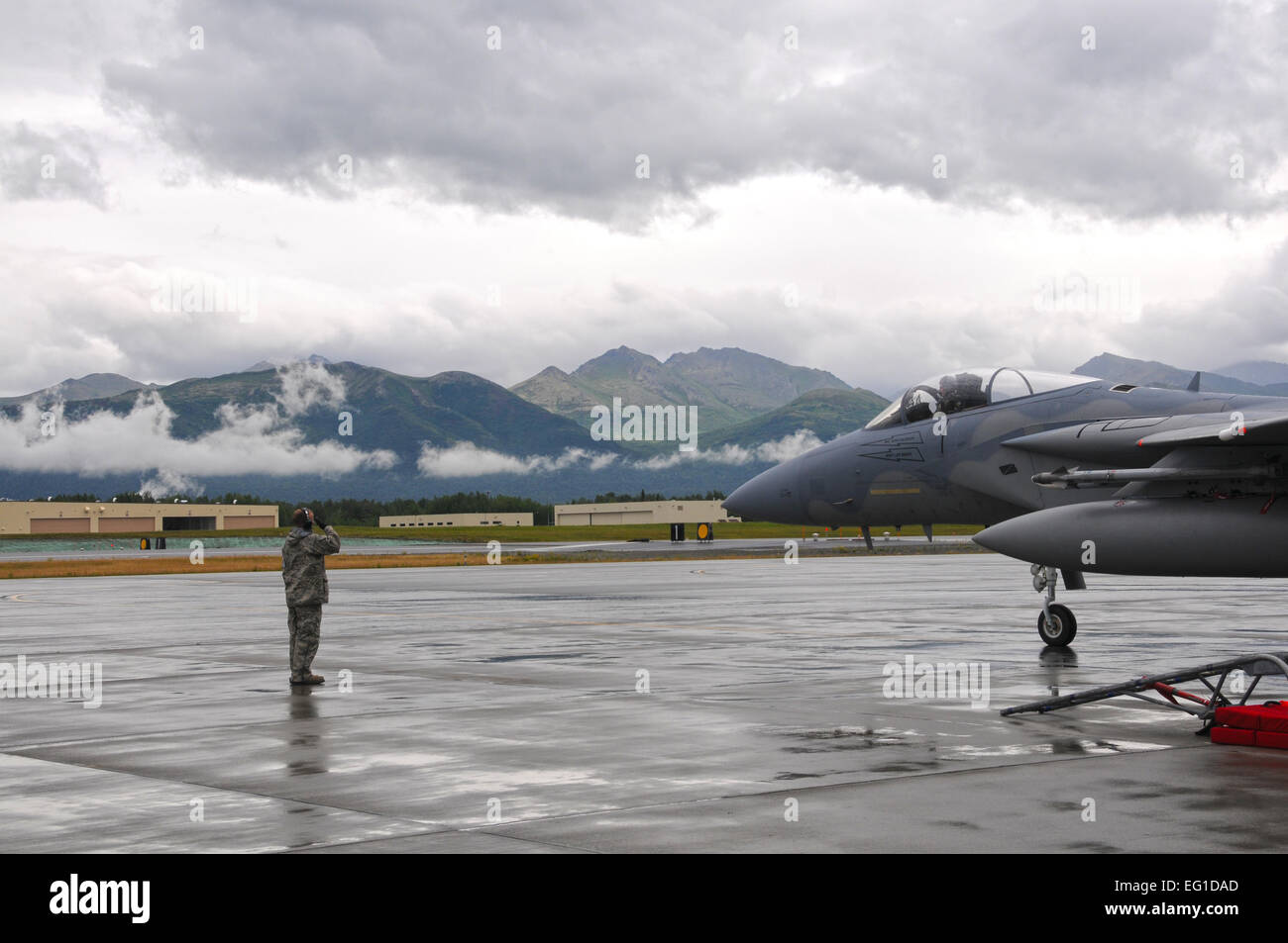US Air Force Staff Sgt Cliff Daley, ein 104. Fighter Wing Crewchief, grüßt der Pilot von einem Jagdflugzeug der Luftwaffe f-15 Eagle, da es gemeinsame Basis Elmendorf-Richardson, Alaska, für eine Ausbildungsmission 1. August 2011 fährt.  Techn. Sgt. Anthony Mutti Stockfoto