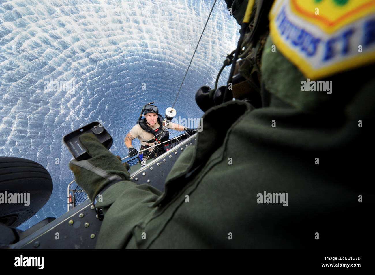 Staff Sgt Jacob Schaumberg, 31. Rescue Squadron Pararescueman an Bord gehievt ein HH-60 Pave Hawk-Hubschrauber von Master Sgt. John Durbin, 33rd Rescue Squadron Flugingenieur und Geschwader Superintendent, während einer gemeinsamen Feld Übung vor der Küste von Okinawa Sept. 1. Mitglieder aus zwei Staffeln zusammen trainiert auf Wasser überleben, Such- und Rettungsmaßnahmen, Luftnahunterstützung, und maritimen Verteidigung und Verbot. Airman 1st Class Jarvie Z. Wallace Stockfoto