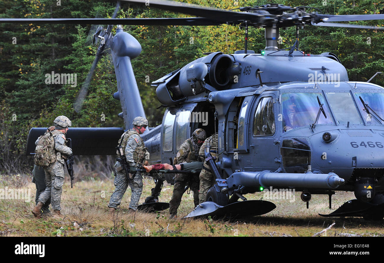 Pararescuemen von der 212th Rescue Squadron und Mitgliedern des Baker Company, 3rd Platoon, 509. Infanterie Regiment Airborne, laden einen Unfall in einem HH - 60G Pavehawk Hubschrauber während des Trainings auf der gemeinsamen Basis Elmendorf-Richardson 21. September 2011.  Die Ausbildung konzentriert sich auf schnell Pflege unter Feuer und gab Training auch Baker Company wie reagieren wenn Pararescuemen ankommen.  Staff Sgt Zachary Wolf Stockfoto