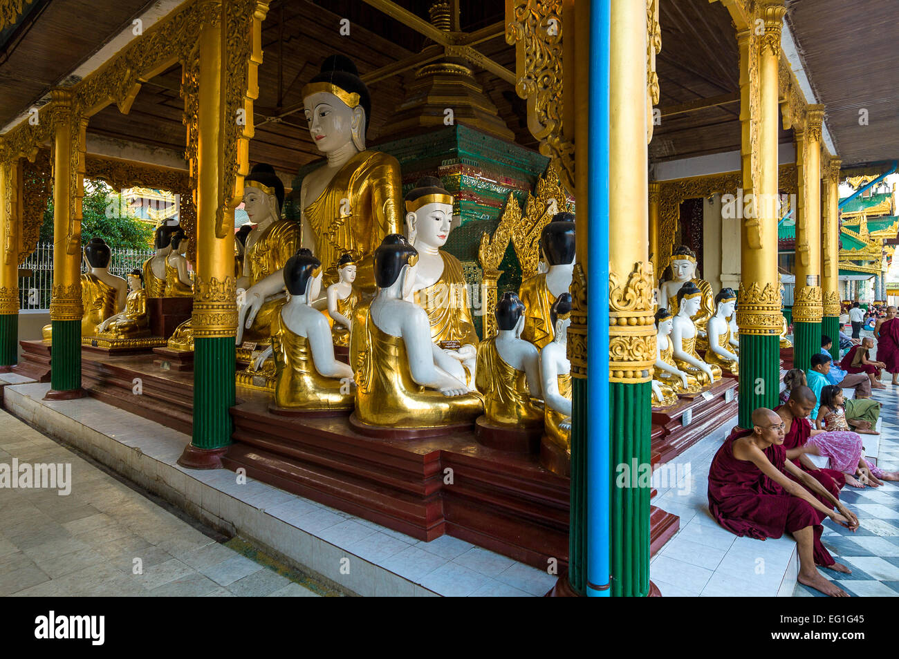 Myanmar, Yangon, Mönche und Sitzplätze in der Nähe von der Buddha-Satues in die Swedagon Pagode. Stockfoto
