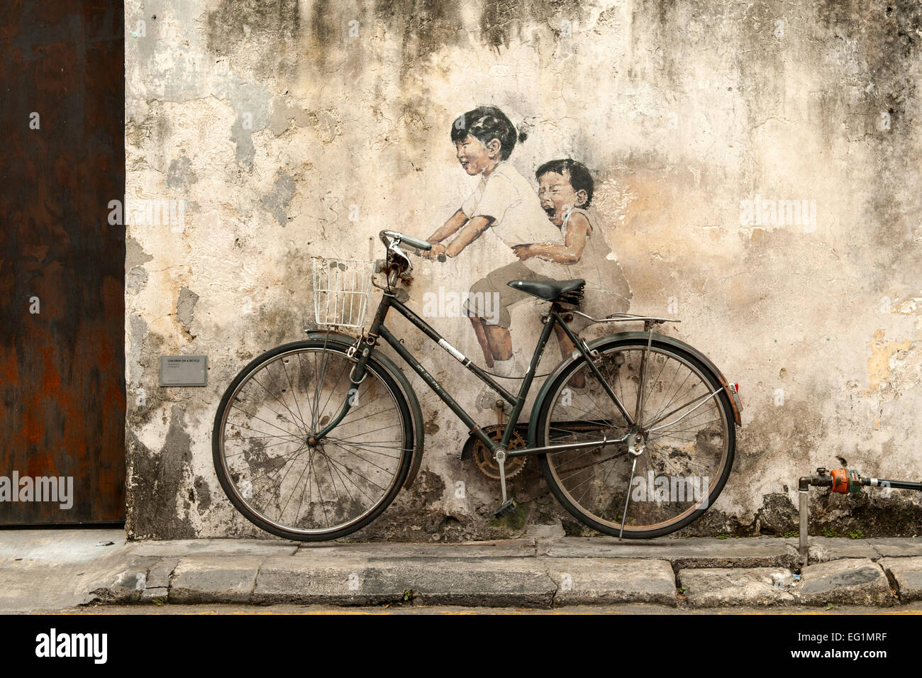 "Kinder auf dem Fahrrad" von Ernest Zacharevic. Es ist Bestandteil der Straßenkunst in Georgetown, der Hauptstadt von Penang in Malaysia. Stockfoto