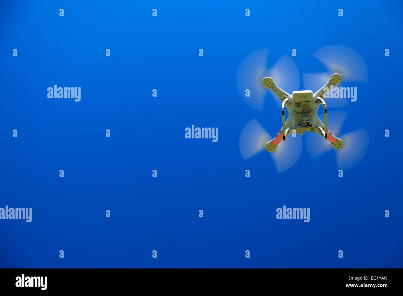 Ein Blick von unten auf eine Drohne mit einem Gimbal und Kamera angebracht. Drohne, Fotografie, fliegen, Überwachung Stockfoto