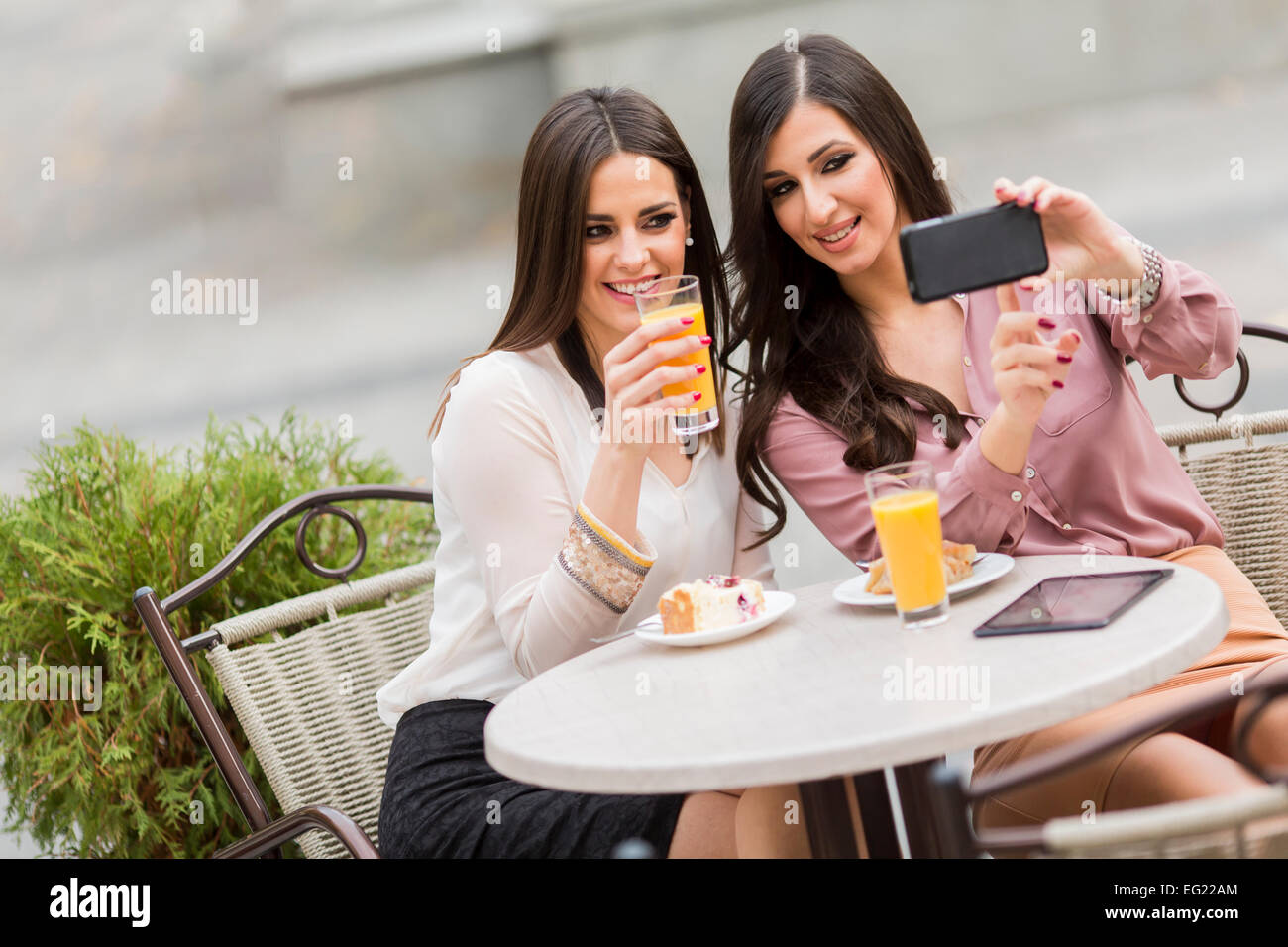 Junge Frauen, die Fotos mit dem Handy im café Stockfoto