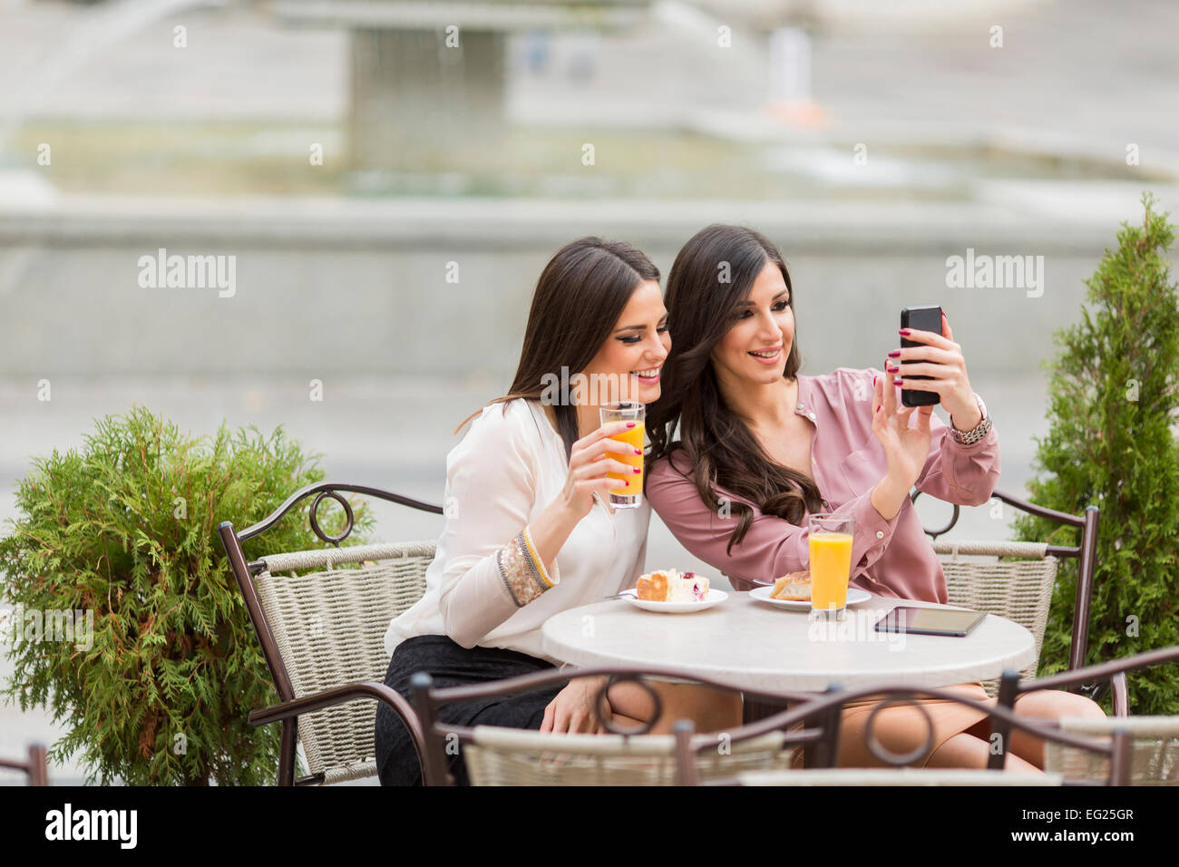 Junge Frauen, die Fotos mit dem Handy im café Stockfoto