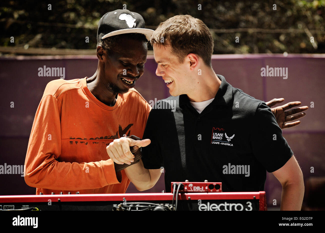 Senior Airman Mike Mitchell lacht mit einem senegalesischen Musiker während eines Konzerts 14. Juni 2014, über ein lokales Kulturzentrum in Dakar, Senegal. US-Luftstreitkräfte in Europa und Afrika Flieger Air Forces wurden im Senegal für den afrikanischen Partnerschaft Flug, ein Programm zur Verbesserung der Kommunikation und Interoperabilität zwischen regionalen Partnern in Afrika.  Mitchell ist ein Keyboarder mit der USAFE-Afrika-Band.  Staff Sgt Ryan Crane Stockfoto