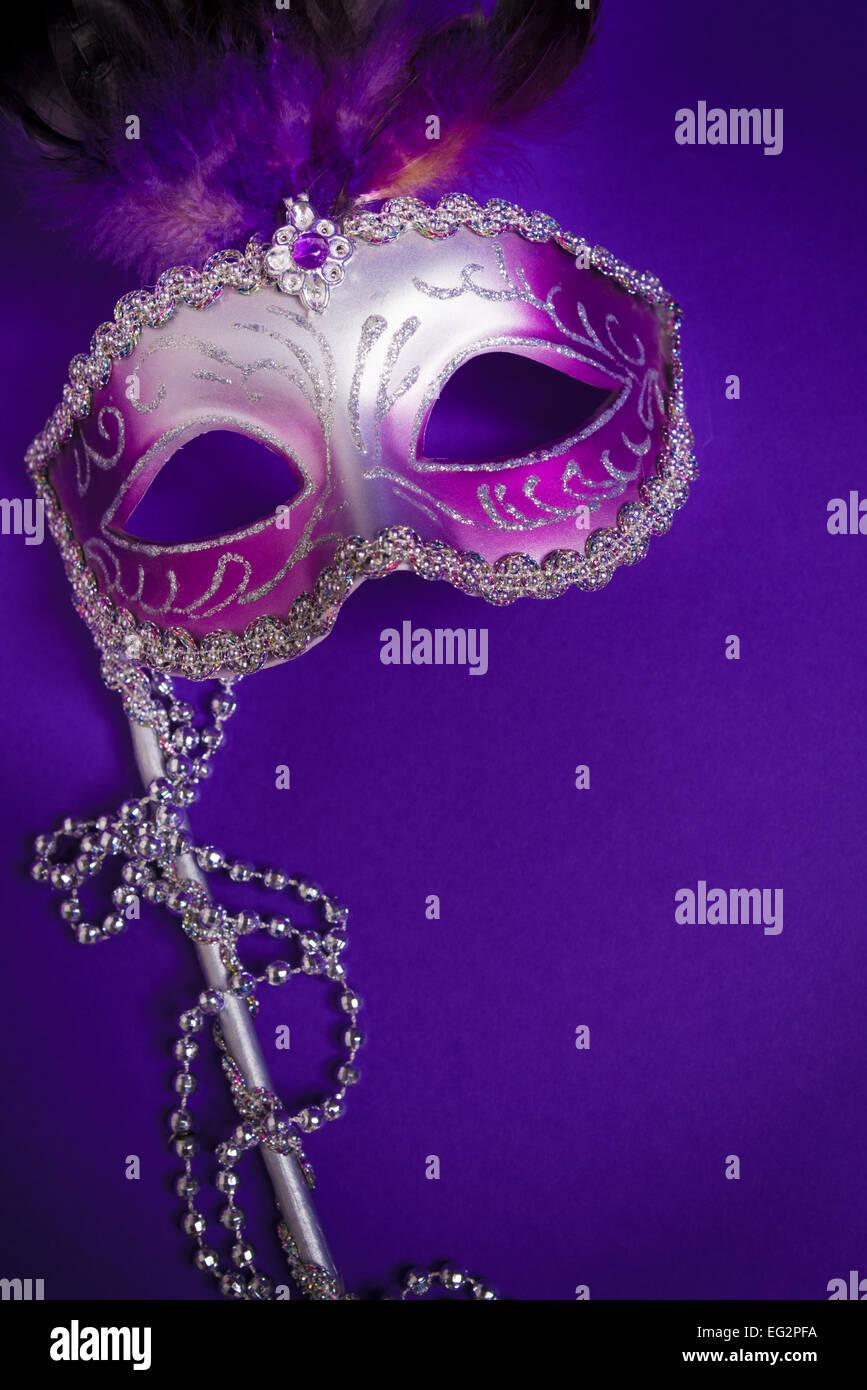 Ein lila Karneval Maske auf lila Hintergrund mit Perlen.  Karneval Kostüm. Stockfoto