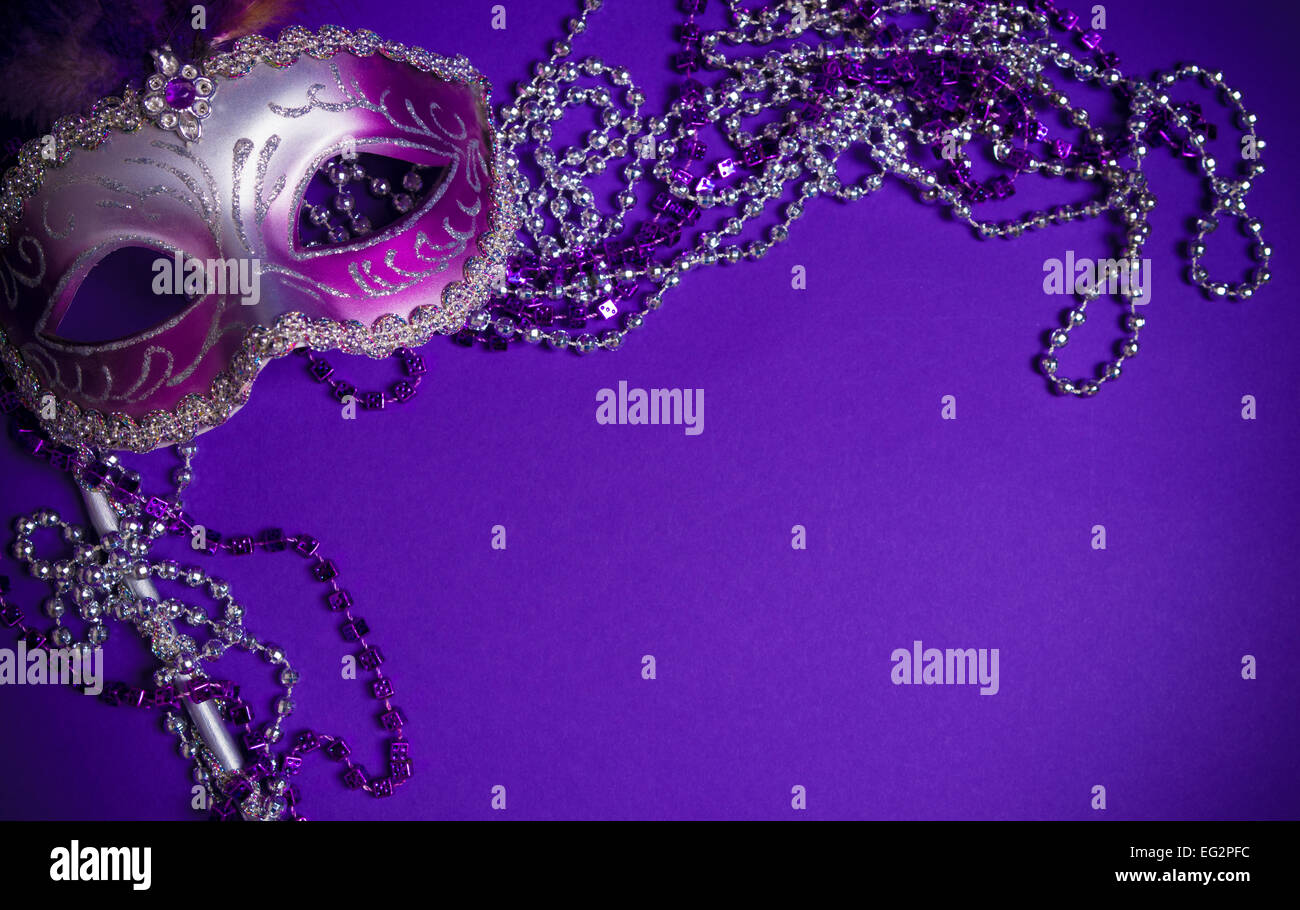 Ein lila Karneval Maske auf lila Hintergrund mit Perlen.  Karneval Kostüm. Stockfoto