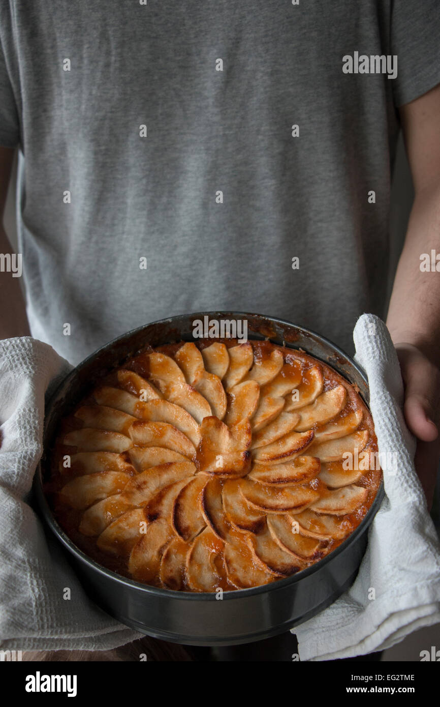 Mann zeigt seine hausgemachten Apfelkuchen mit Stolz und Liebe Stockfoto