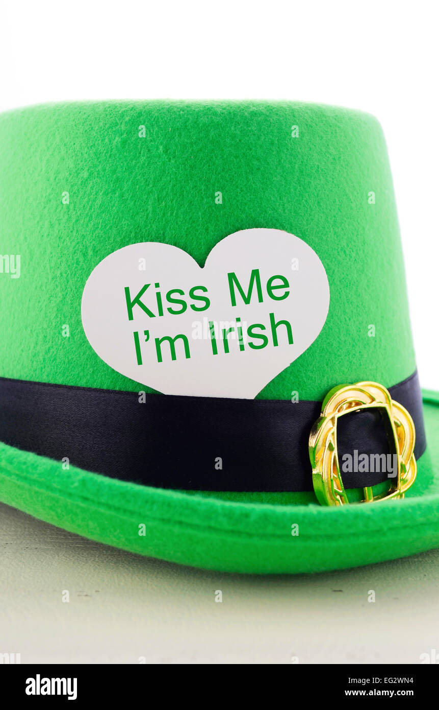 Happy St Patricks Day Grünen Kobold Hut auf weißer Holztisch mit Kiss Me ich bin irische Herzform Gruß Zeichen, vertikale. Stockfoto