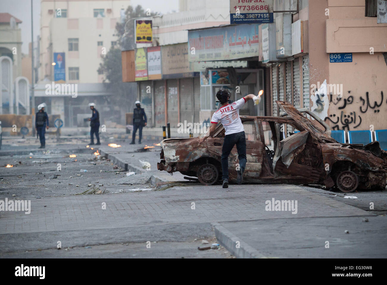 Manama, Bahrain. 14. Februar 2015. Demonstrant wirft einen Molotov-Cocktail am Fuße des der Gruppe und Sicherheitskräfte, die die Zusammenstöße am vierten Jahrestag des bahrainischen Aufstands, namens Revolution am 14. Februar in Sitra südlich der Hauptstadt Manama getretenen unterdrücken. Bildnachweis: Ali Hussain/Pacific Press/Alamy Live-Nachrichten Stockfoto