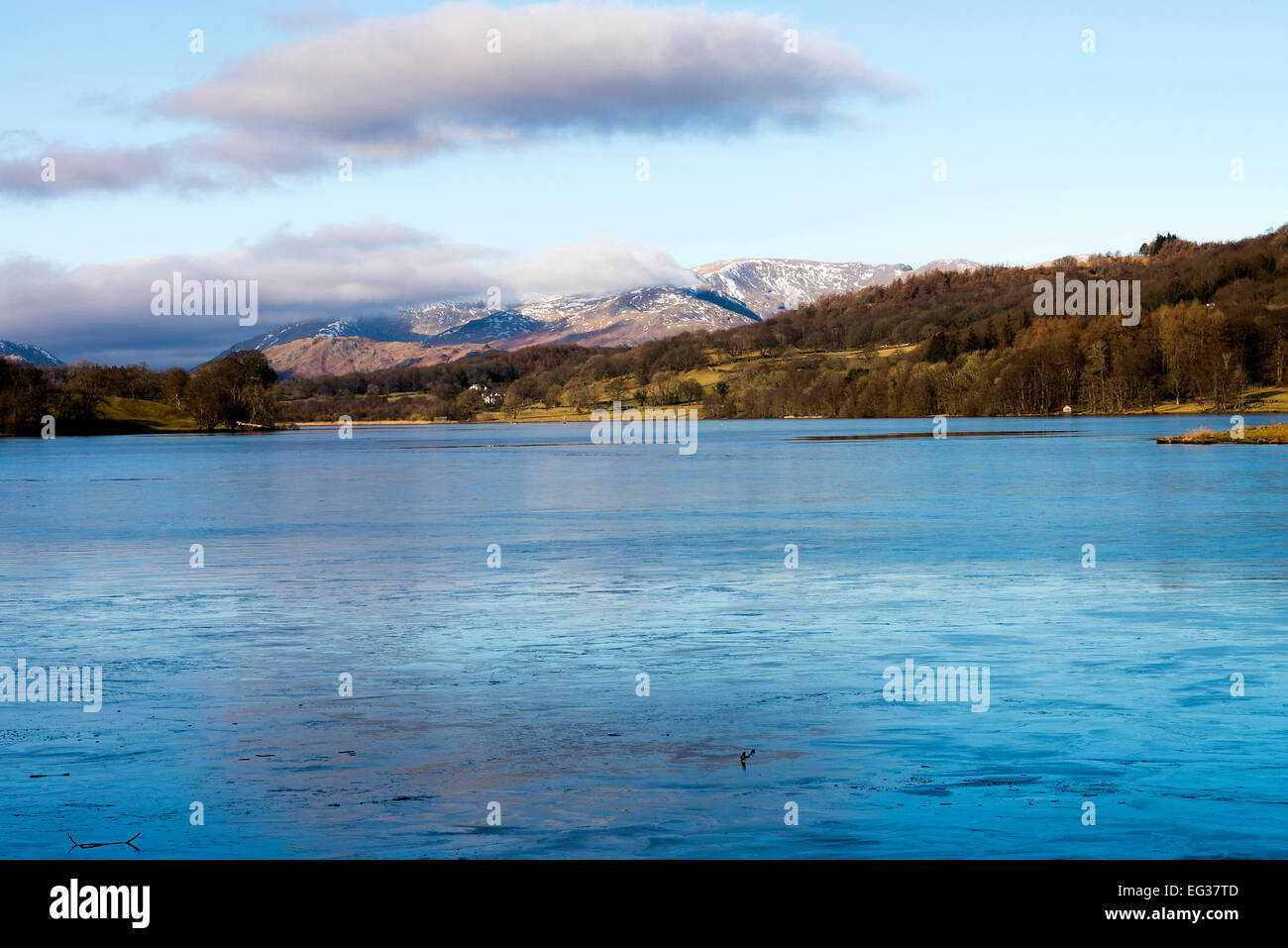 Eine dünne Schicht von Eis bedeckt Esthwaite Wasser mit den Lakeland-Hügeln im Hintergrund auf einen Winter Tag Seenplatte Cumbria England Stockfoto