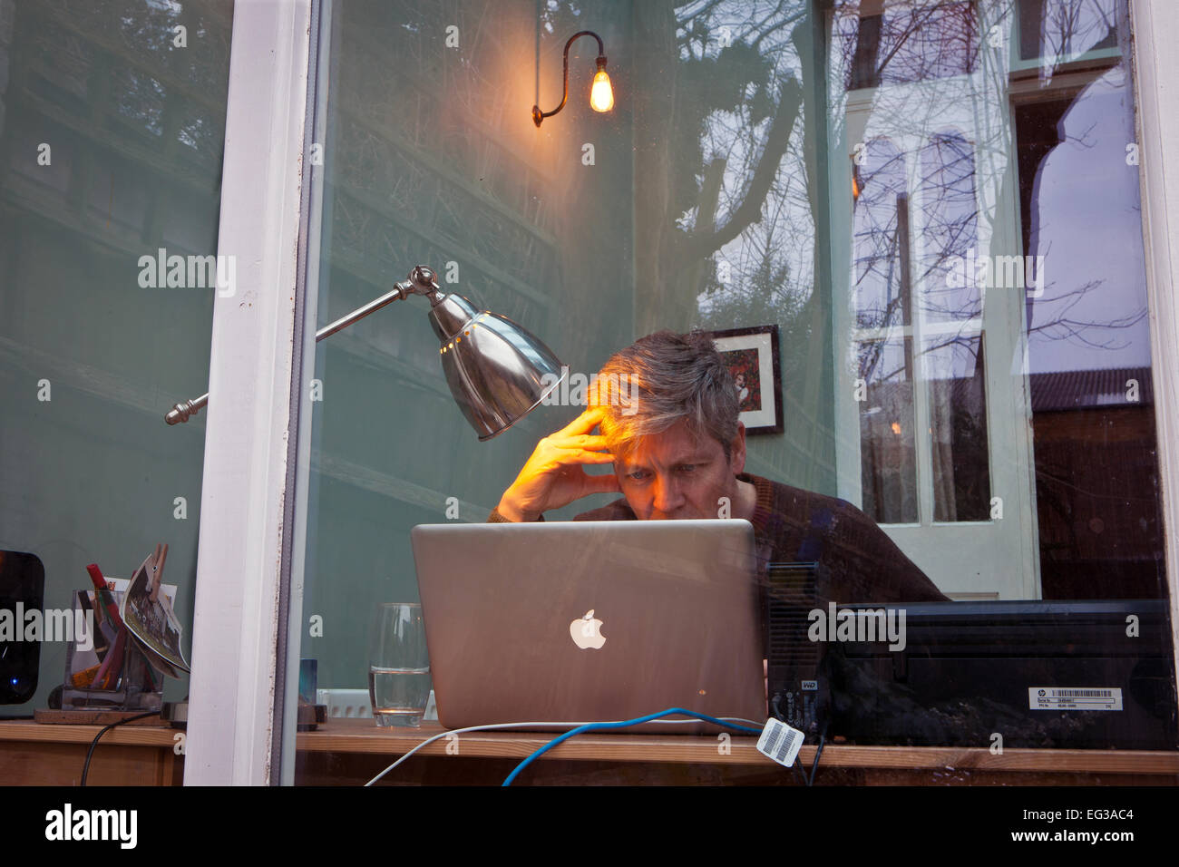 Mann gesehen Trog Fenster auf Laptop Apple Maccomputer Stockfoto