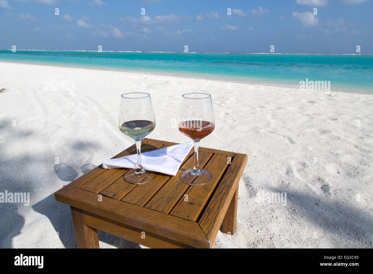 Dies sind 2 Gläser Wein auf einer Smalltable an einem epischen Strand. Stockfoto