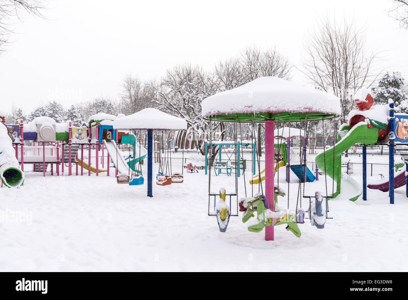 Kinderspielplatz im öffentlichen Park mit Schnee bedeckt Stockfoto