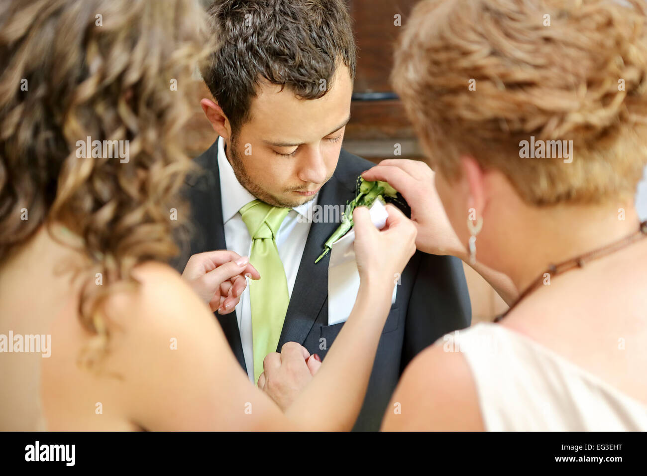 Pinning Boutonniere Blumen an den Bräutigam vor der Hochzeitszeremonie Stockfoto