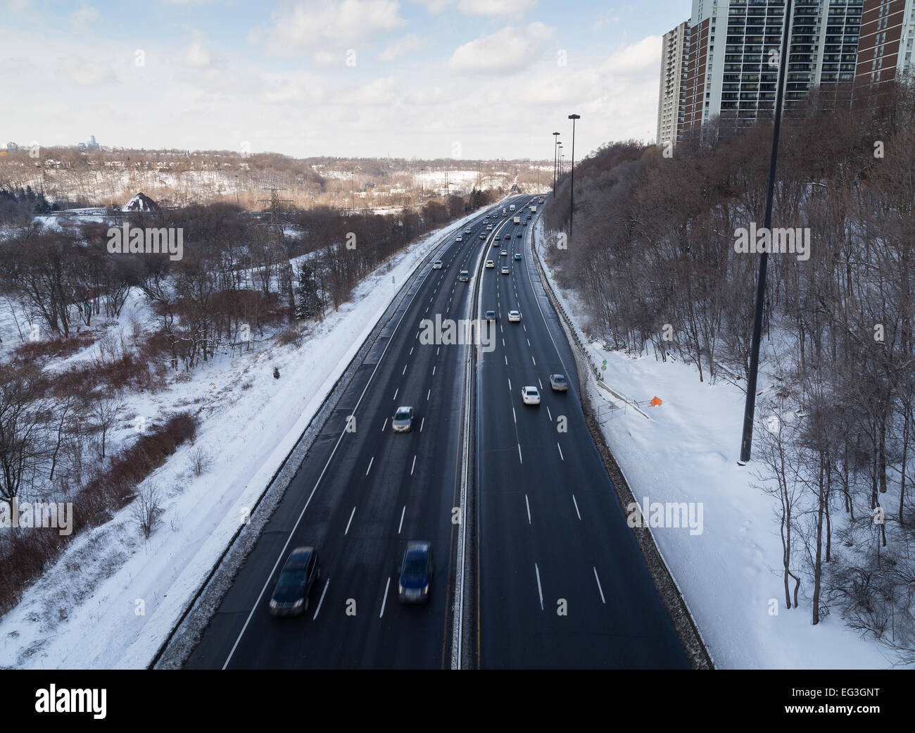 Eine hohe Ansicht des Don Valley Parkway im Winter mit Schnee an der Seite der Straße und Autos Stockfoto