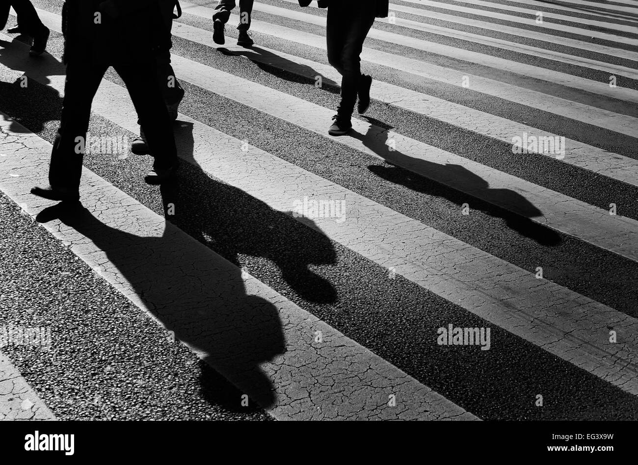 schwarz / weiß Foto von Menschen und Schatten zu Fuß auf einer Stadt Straßenkreuzung, Budapest Ungarn. Stockfoto