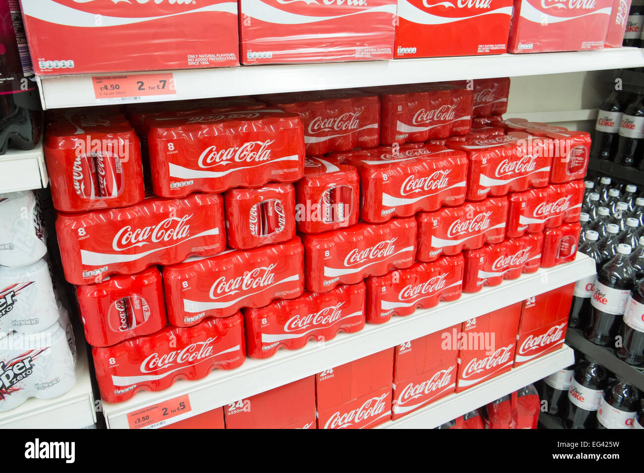 Dosen von Coca Cola zum Verkauf in einem Sainsburys Supermarkt in Derbyshire, England Stockfoto