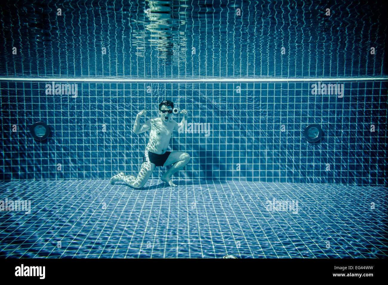 Mann posiert als Superman Unterwasser Schwimmbad Stockfoto