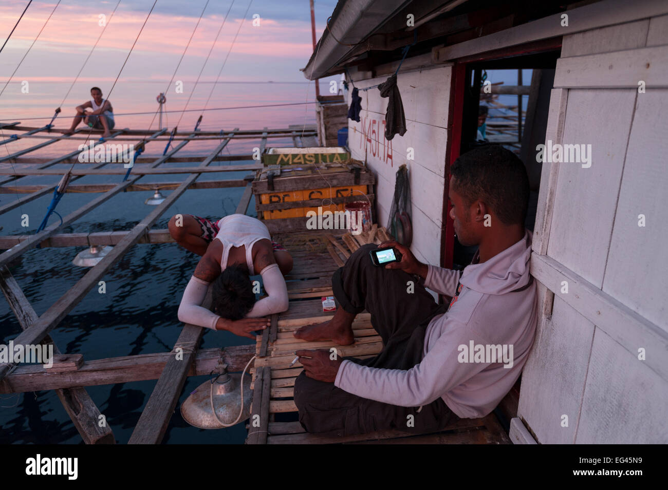 Männer auf Fischerei-Gerät namens? Bagan? stationäre Auslegerboot Netto zwischen Ausleger starkes Licht in der Nacht, Sardellen Scad zu gewinnen. Cenderawasih Bay Provinz Papua Indonesien April 2012 Stockfoto