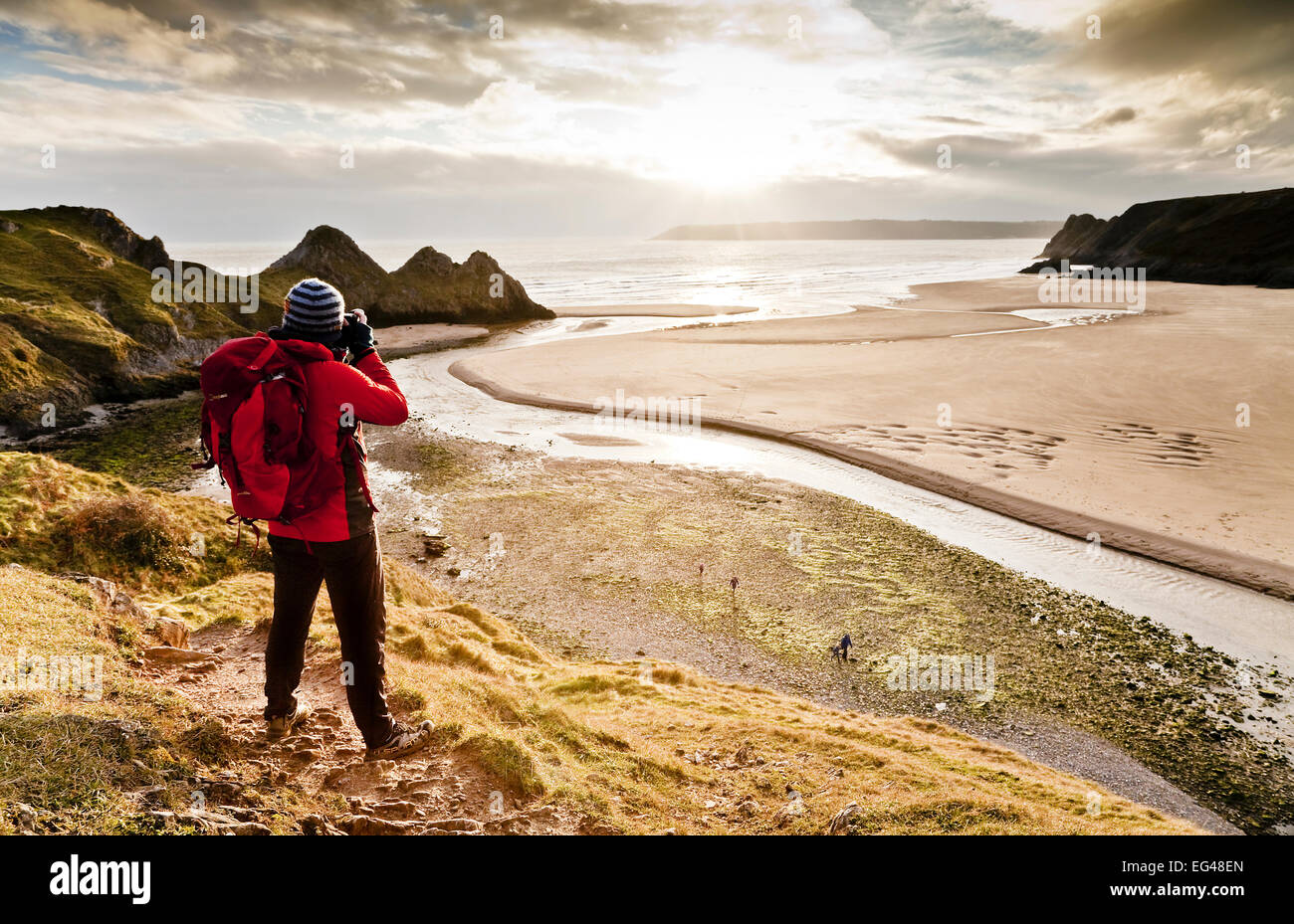 Mann unter Foto drei Klippen Bucht Gower Swansea Wales. Januar 2013. -Modell veröffentlicht. Stockfoto