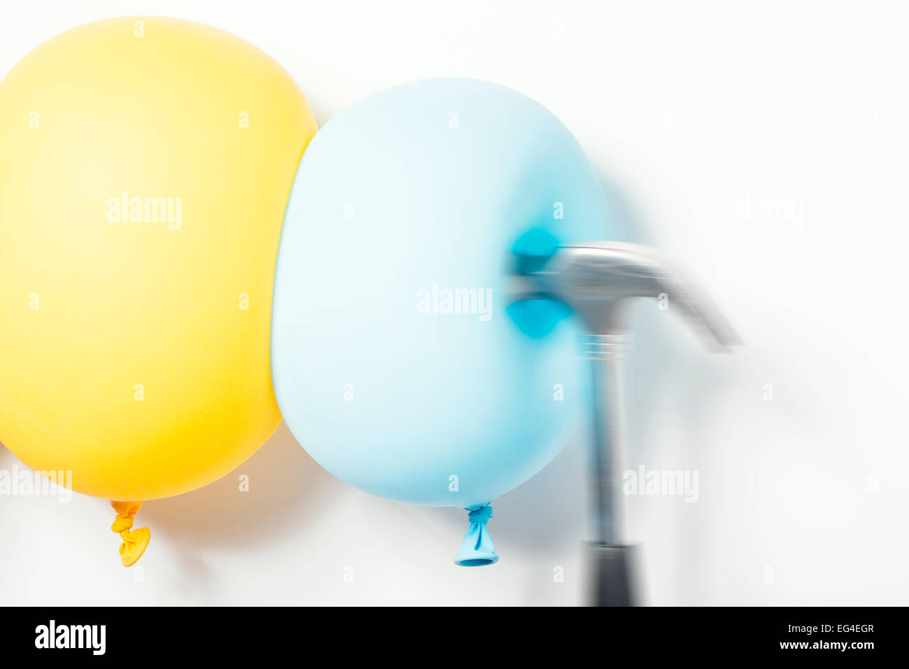 Hammer schlagen Ballons. Konzeptbild Kontraste, Beständigkeit und Festigkeit. Stockfoto