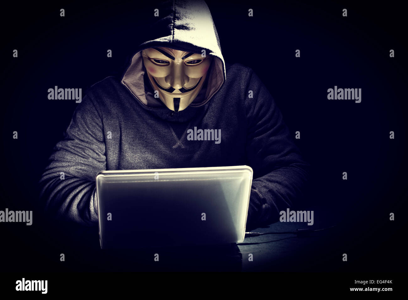 Hacker mit Maske bei der Arbeit Stockfoto