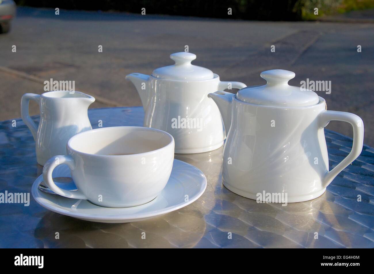 Tasse Tee und Teekanne auf Edelstahl-Tisch. Stockfoto