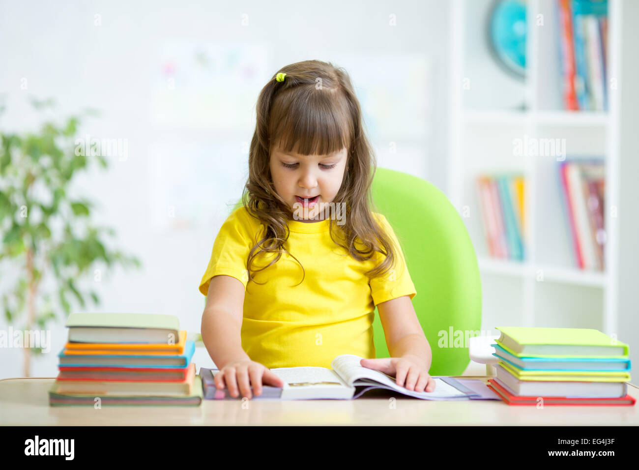 Kind-Lesebuch am Tisch im Kindergarten Stockfoto