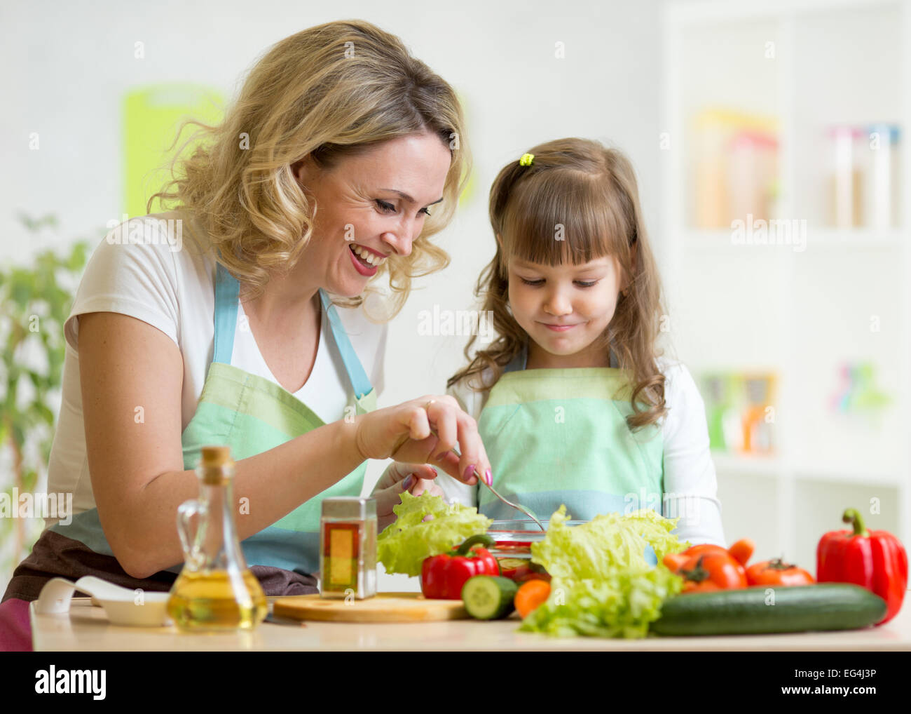 Mutter und Kind vorbereiten und gesundes Essen zu Kosten Stockfoto