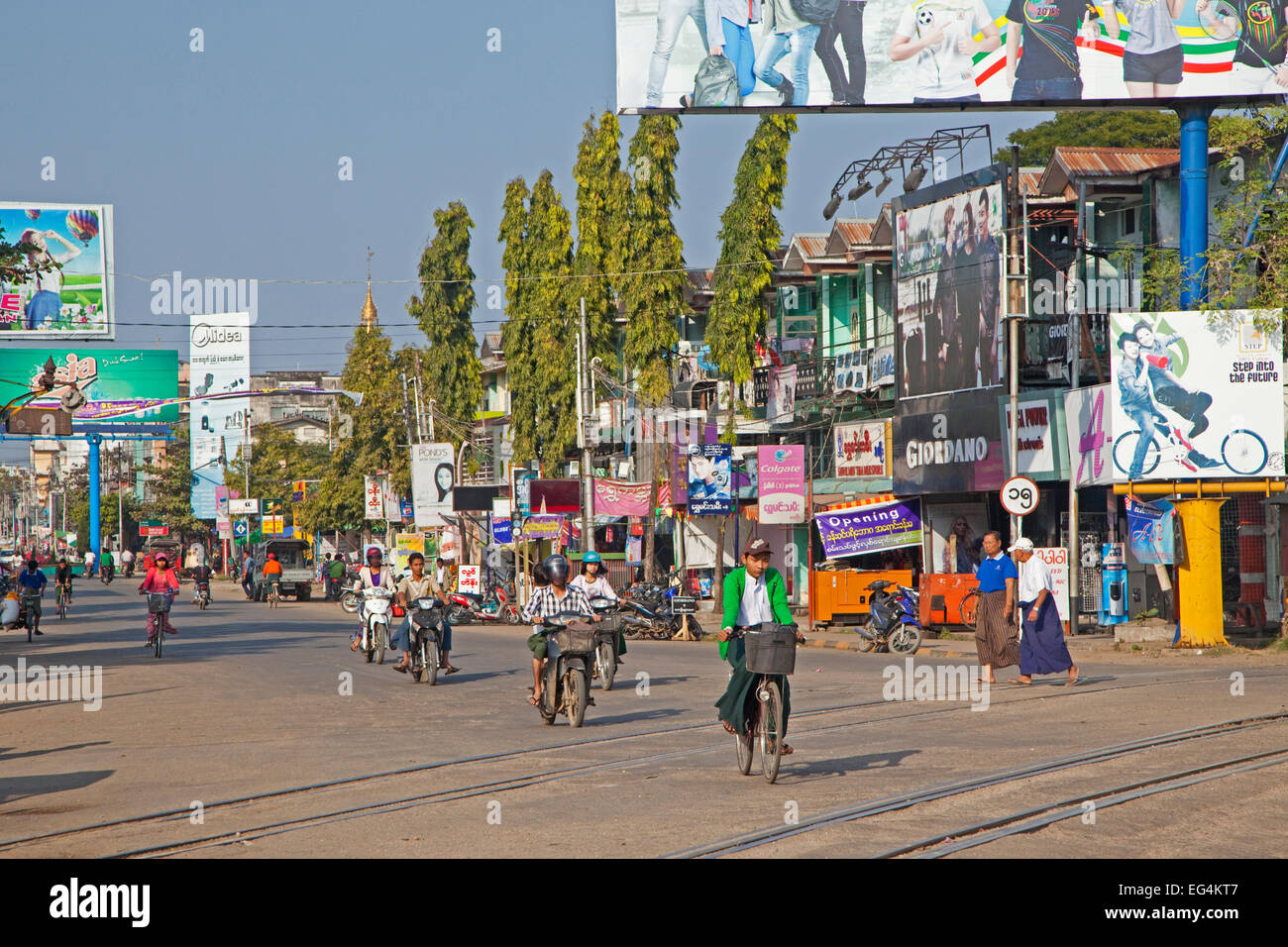 Radfahrer und Motorradfahrer in Einkaufsstraße in Pyay / Prome, Bago Region, Myanmar / Burma Stockfoto