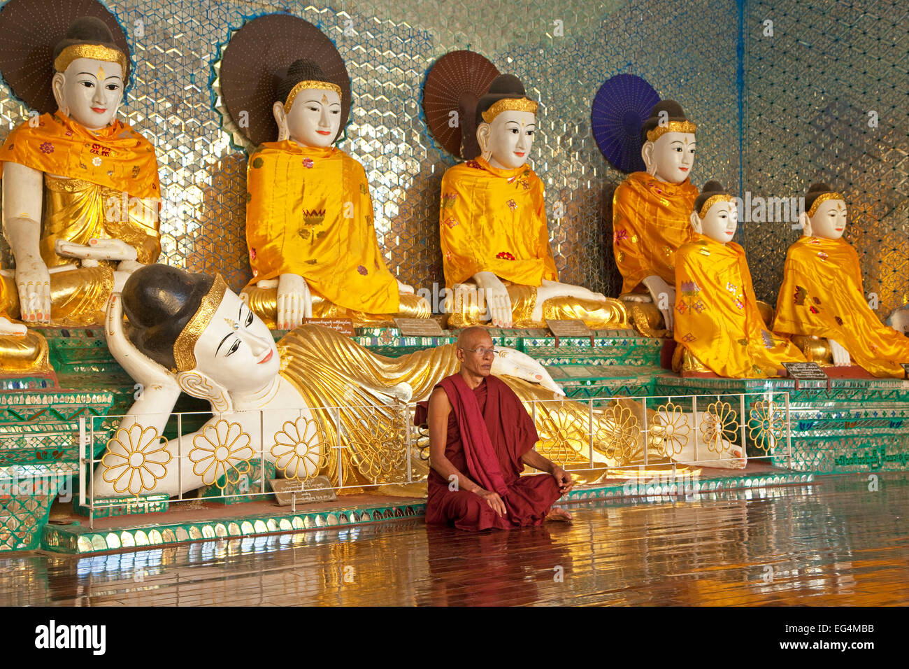 Buddhistischer Mönch betend vor Buddha-Statuen in der Shwedagon Zedi ...