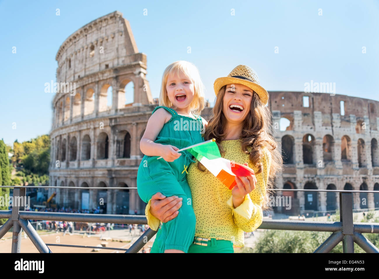 Glückliche Mutter und Babymädchen mit italienischer Flagge vor dem Kolosseum in Rom, Italien Stockfoto