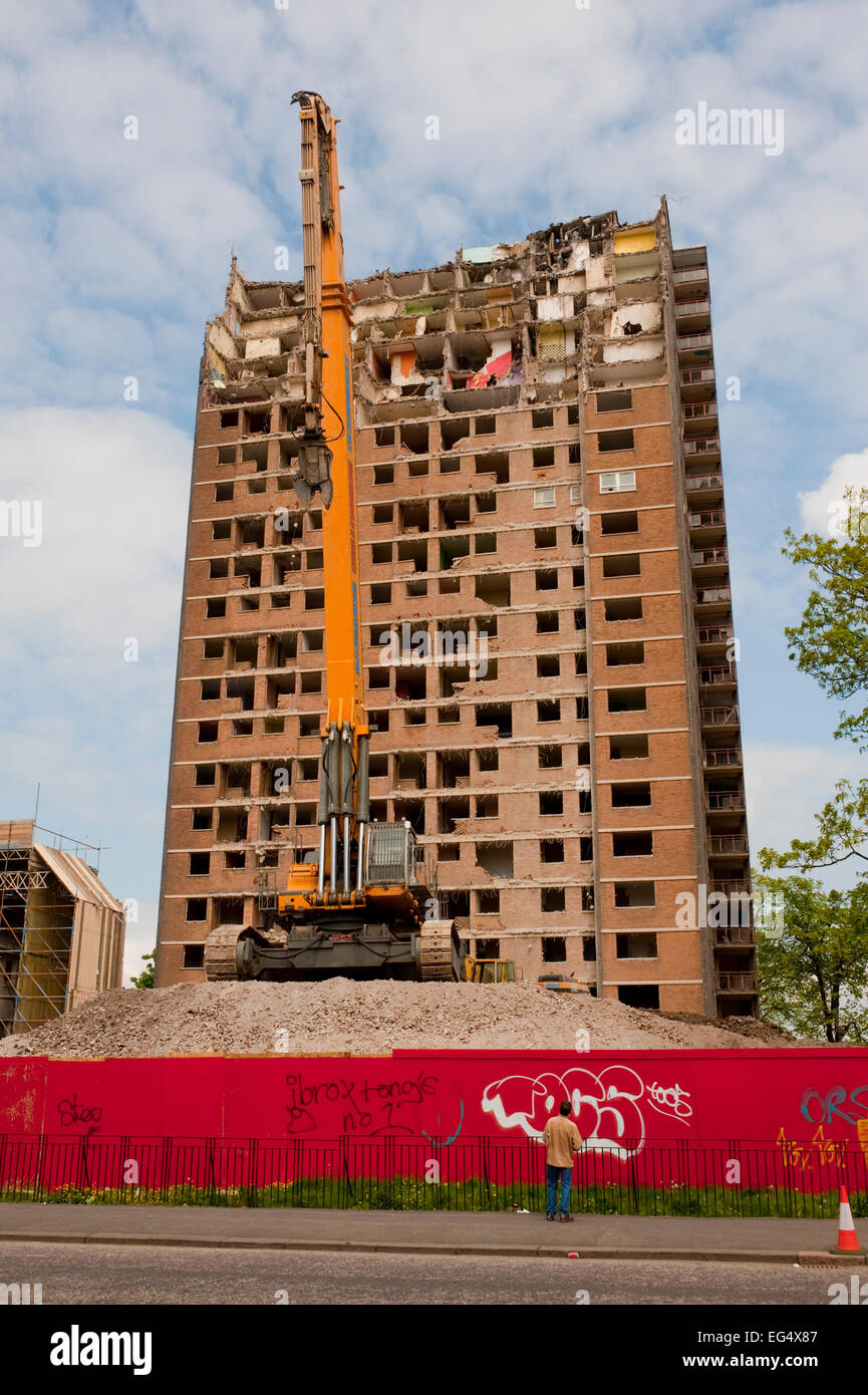 Ein Abbruch Kran sitzt vor einer teilweise abgerissen Hochhaus im Ibrox, in der Nähe von Govan im Süden westlich von Glasgow. Stockfoto