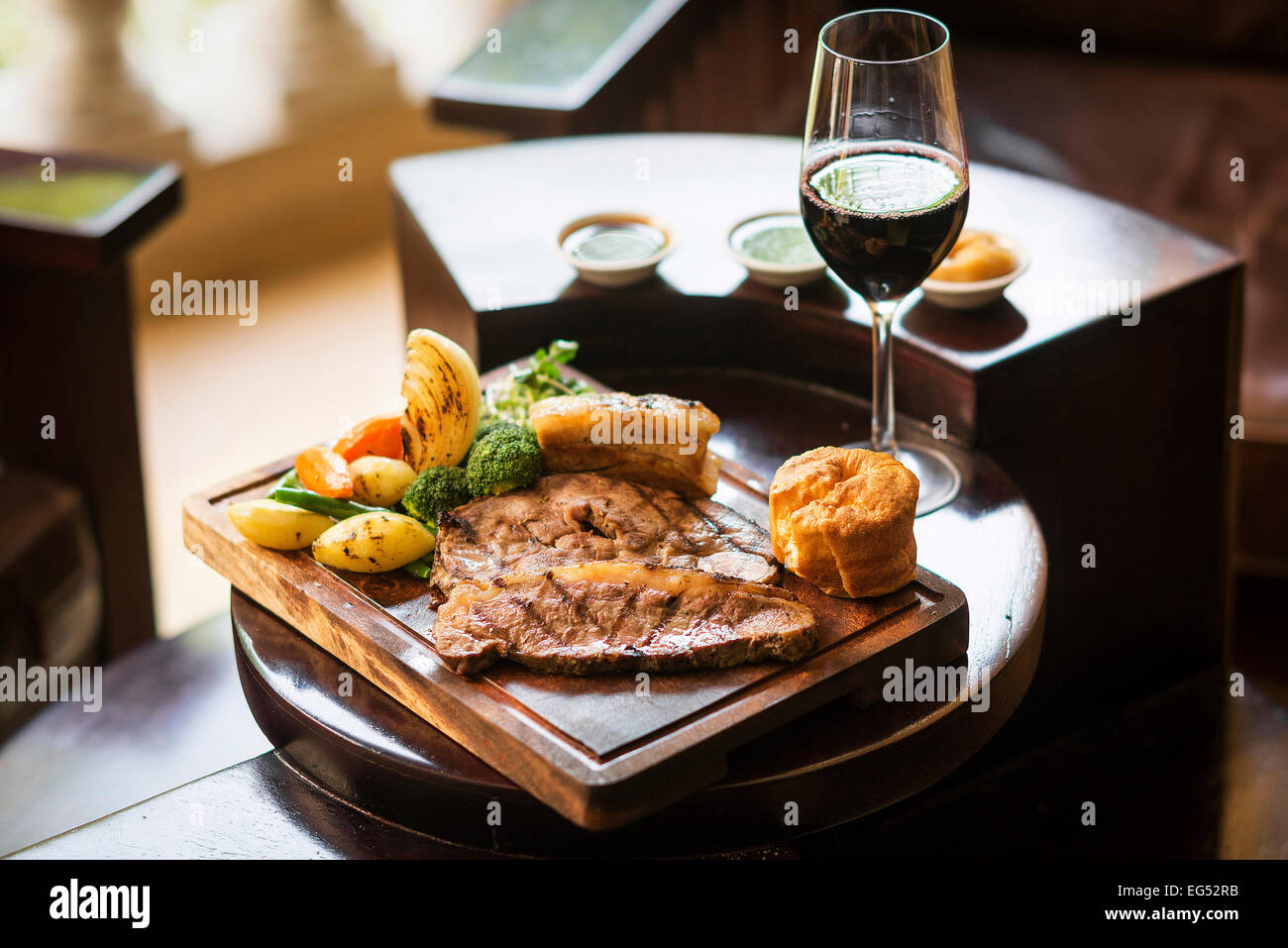 traditionelles englisches Essen Sonntag Braten Mittagessen im gemütlichen Restaurant Pub mit Glas Rotwein Stockfoto
