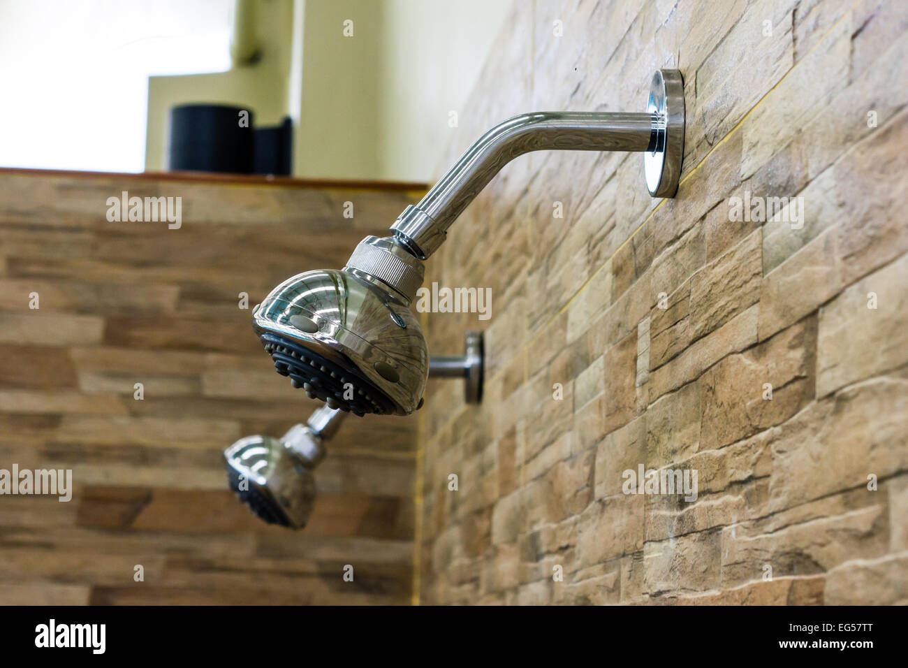 Der Bad-Dusche-Kopf auf der Steinmauer Stockfoto