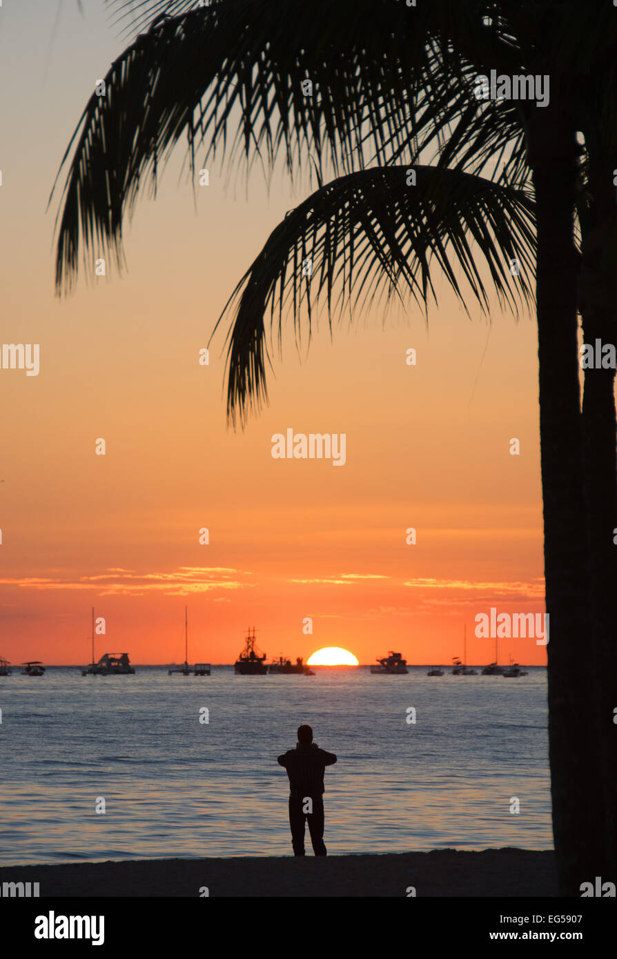 Dominikanische Republik. Ein Urlauber fotografieren den Sonnenaufgang am Strand von Punta Cana an der Atlantikküste. 2015. Stockfoto