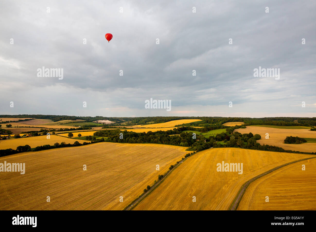 Fernsicht auf roten Heißluftballon über ländliche Landschaft fliegen, South Oxfordshire, England Stockfoto